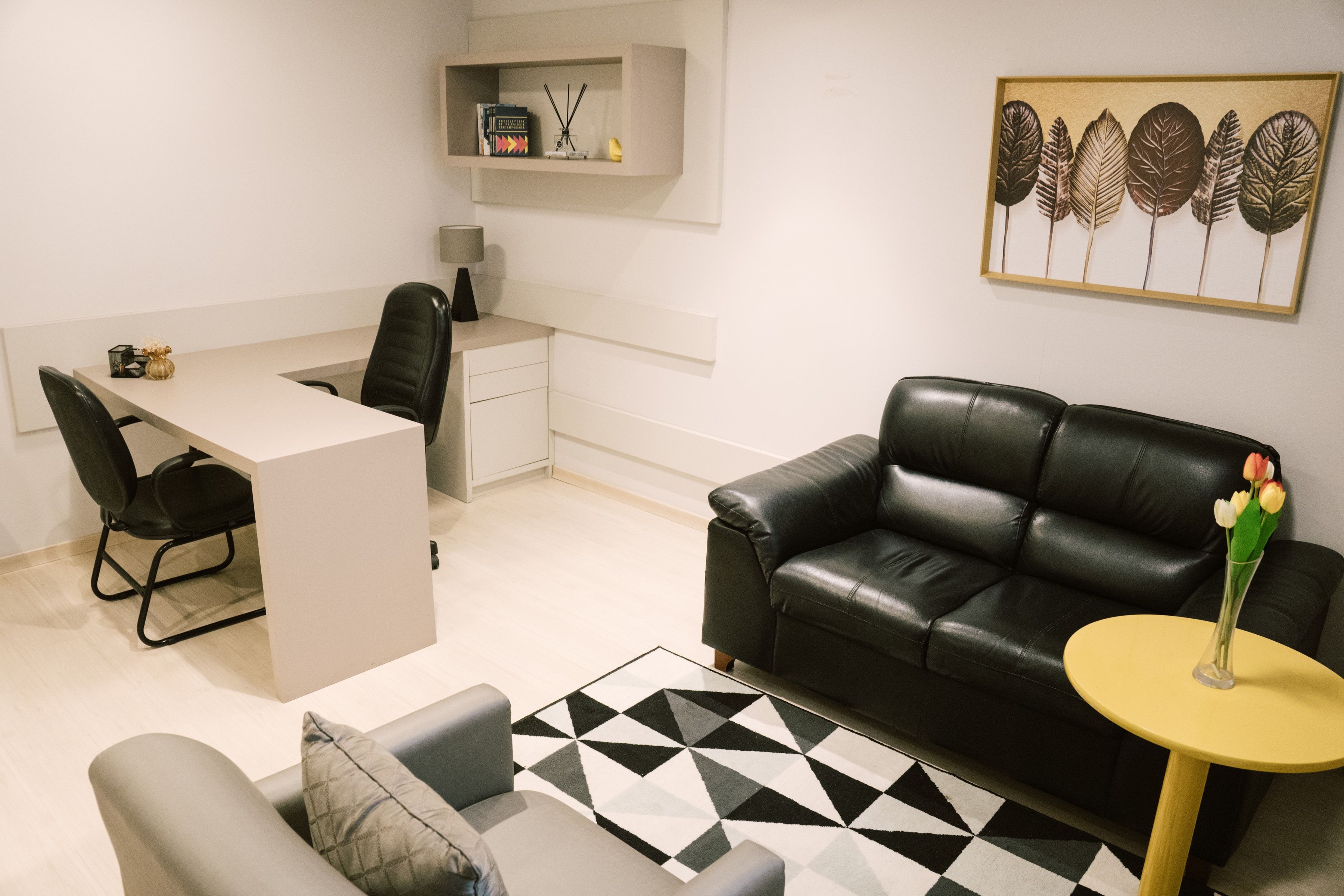 Sala 101 da Willtay com mesa de trabalho, sofá de couro e poltrona