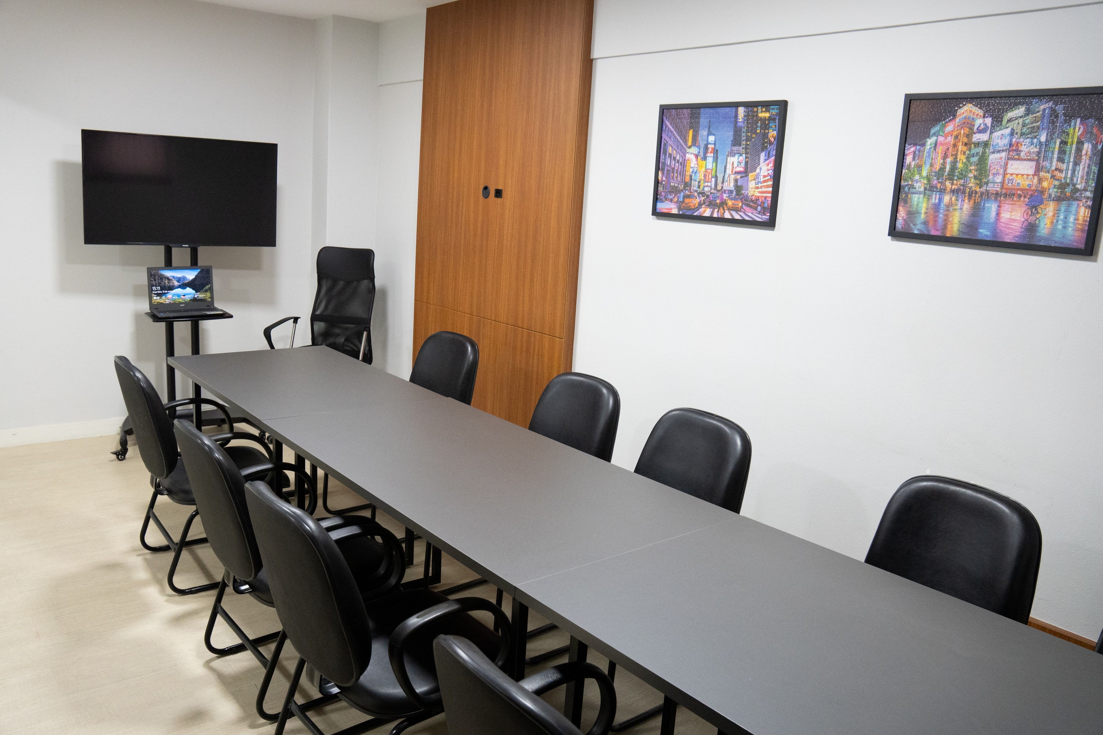 Sala de reunião da Willtay Coworking, com mesa para grupos e TV