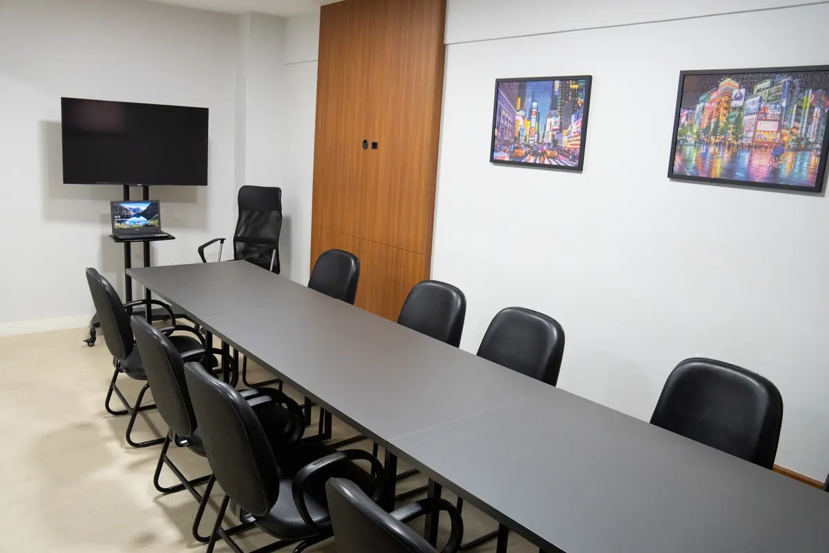 Sala de reunião da Willtay Coworking com mesa para grupos, TV e quadros