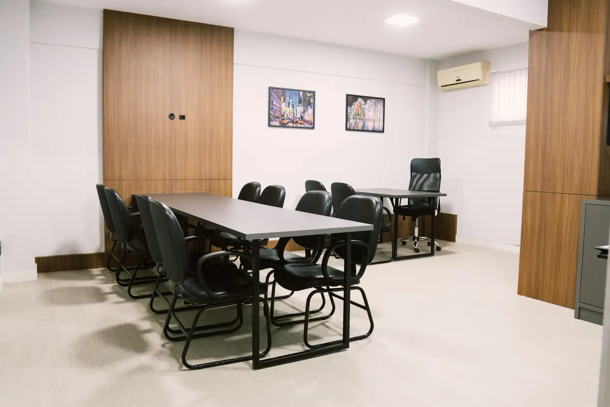 Vista geral da sala de reunião com mesa para grupos
