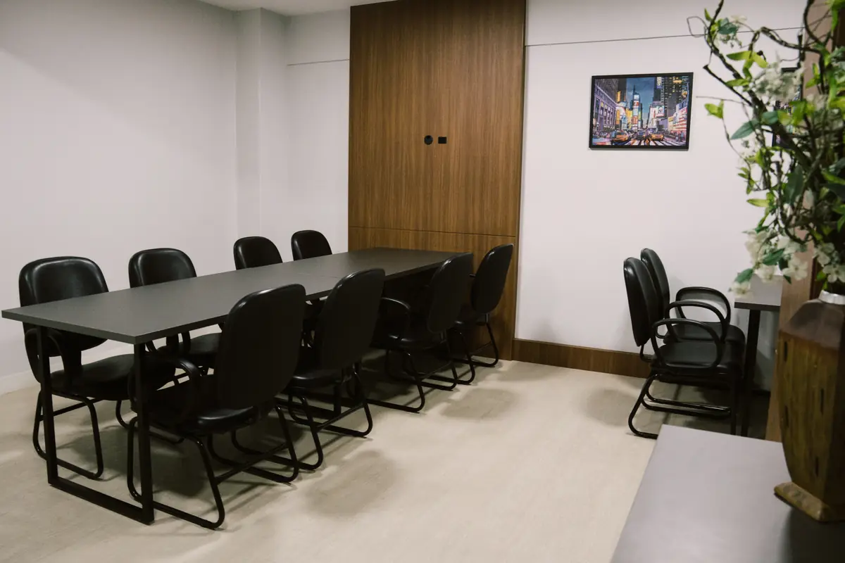 Mesa de reunião com cadeiras e planta decorativa