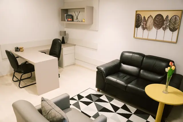 Sala 101 da Willtay Coworking em Brusque: mesa de trabalho em L, área de estar com sofá de couro e poltrona