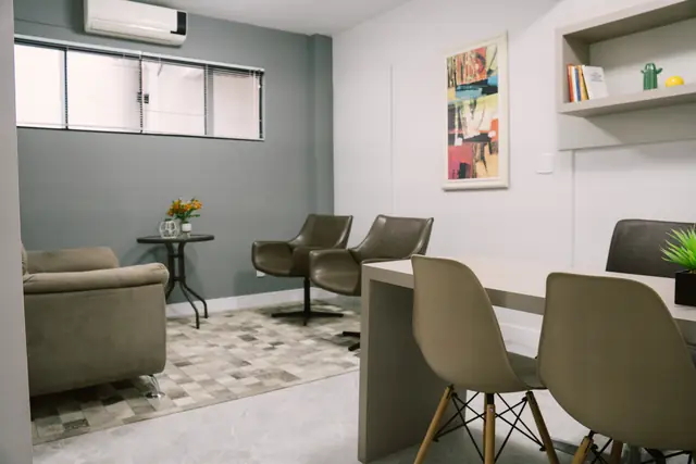 Sala 103 da Willtay Coworking em Brusque: mesa com cadeiras, par de poltronas giratórias e janela