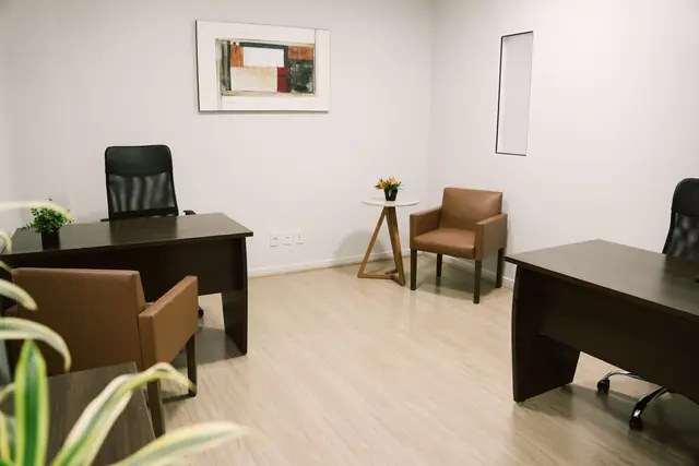 Sala 206 da Willtay Coworking em Brusque: duas mesas de trabalho em madeira escura, poltronas e armários baixos