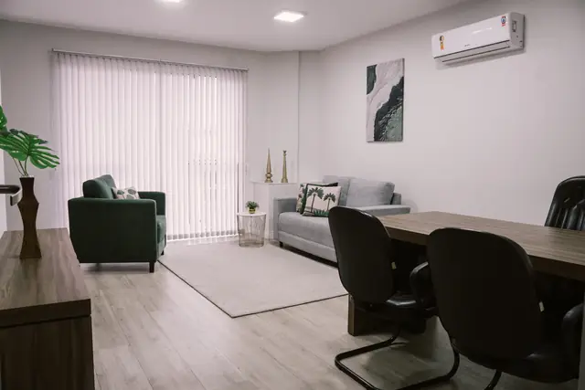 Sala 210 da Willtay Coworking em Brusque: mesa de trabalho, sofá cinza e poltrona verde